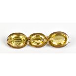 A yellow metal and oval citrine three stone brooch, length 4.5cm, approx 5.1g.