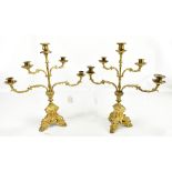 A pair of gilt metal ecclesiastical five sconce candelabra with cast foliate detail and crosses to