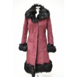 BAILY'S OF GLASTONBURY; an aubergine coloured full length sheepskin coat with black faux fur lining,
