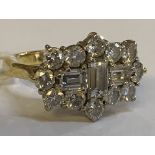 An 18ct yellow gold and diamond cluster ring, centred with three baguette cut stones within a border