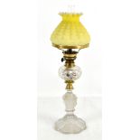 ST LOUIS; an oil lamp with crimped opaque yellow glass shade above clear hobnail cut reservoir on