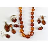 A group of amber jewellery to include a graduated beaded necklace, a pendant and earrings, etc.