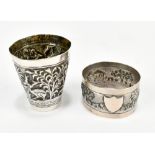 A South East Asian white metal tot cup with repousse flora and fauna decoration, height 5.2cm, and a