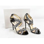 JIMMY CHOO, LOTTIE; a pair of black patent leather and woven faux-raffia strap sandal with a 100mm/4