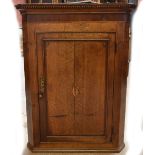 A late George III oak corner cupboard.
