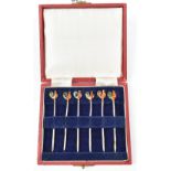 ADIE BROS LTD; a cased set of six George VI hallmarked silver cocktail sticks with gilt finish and