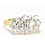 A yellow metal diamond ring with three central rectangular diamonds within a border of twelve