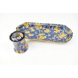 ROYAL DOULTON; an oval dressing table tray and similar hat pin holder, decorated with yellow blossom