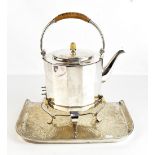 An Arts & Crafts silver plated electric kettle on stand with rattan detail to the swing loop handle,