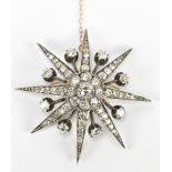 A yellow and white metal diamond starburst pendant/brooch, set with approximately 5.7ct total, the
