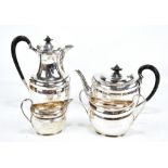 ATKIN BROS; a George V hallmarked silver four piece tea set comprising teapot, length 26.5cm, hot