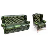 A green leather button upholstered wing back three seater settee with matching chair on cabriole