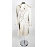 HERMÈS; a beige cotton trench coat, belted with tortoise shell buckles, that can be worn three ways,