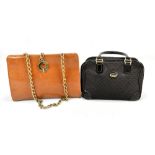 GUCCI; a black monogrammed fabric and black leather handbag, with gold tone hardware, and