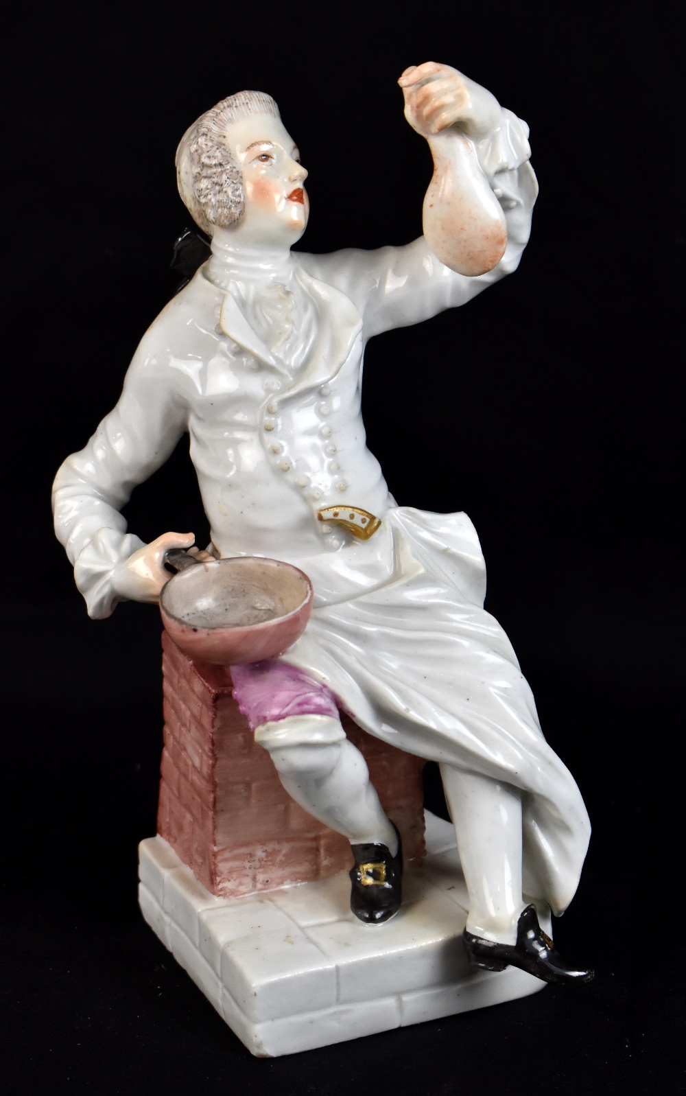 MEISSEN; a mid-18th century figure of a seated cook modelled by JJ Kaendler and Paul Reinicke, circa