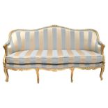 A 19th century gilt wood settee in the French taste with floral carved detail, striped padded back