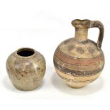 An early pottery jug with pinched spout and bands of decoration in shades of brown, height 25cm,