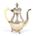 A Russian silver coffee pot of baluster form with hexagonal finial and ivory handle, raised on three