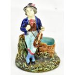 A Victorian majolica figural spill vase modelled as a young gentleman playing the violin,