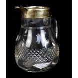 THE ALEXANDER CLARK MANUFACTURING CO; a clear cut glass water jug with Victorian hallmarked silver