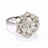 A white metal diamond cluster ring, the central diamond weighing approx .25ct, the inner band