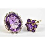 Two yellow and white metal dress rings both set with purple coloured stones, both with rubbed