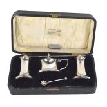 A cased George V hallmarked silver three piece cruet set with integral liners, Birmingham 1934,