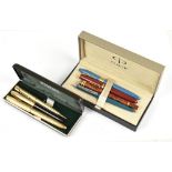 A small group of pens including a Parker red bodied Duofold, a blue bodied pen, etc.