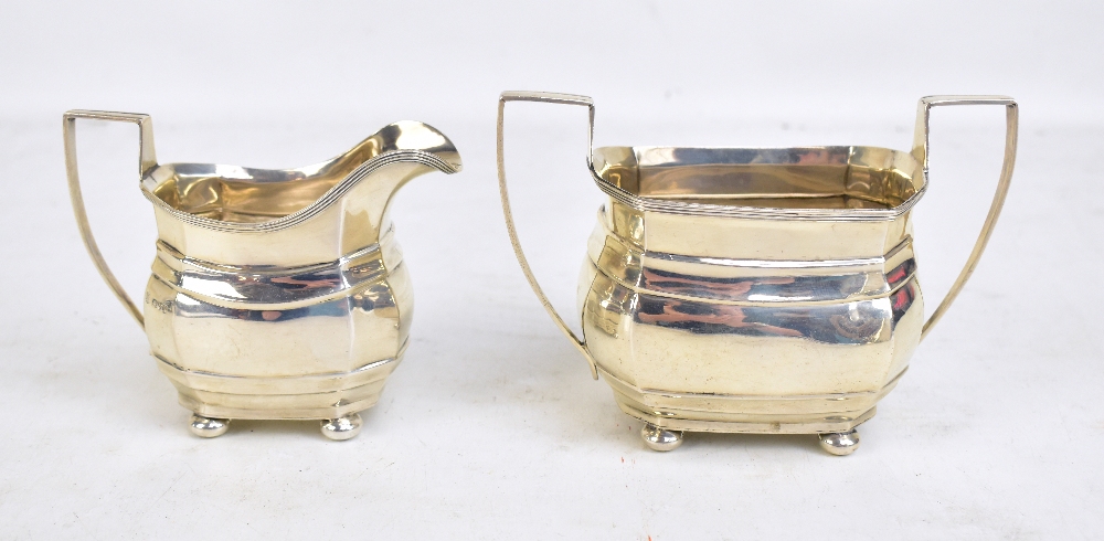 GEORGE NATHAN & RIDLEY HAYES; a George V hallmarked silver twin handled sugar bowl and cream jug