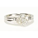 An 18ct white gold seven stone diamond and floral cluster ring totalling approx 0.33cts, size M 1/2,