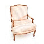 DERWENT; an open sided armchair upholstered in a striped material, raised on carved cabriole