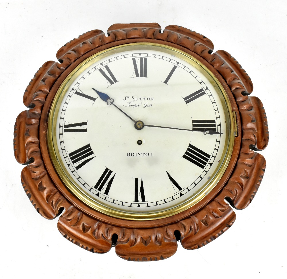 A carved walnut cased wall clock with repainted dial set with Roman numerals and inscribed 'J.N