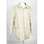 HERMÈS; a vintage taupe coloured quilted jacket with pop stud fastenings and front pockets, size 40,