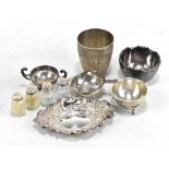 A small group of silver including a pin dish, tea strainer on stand, small twin handled cup, and a