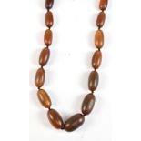 A graduated necklace of carved rhino horn beads, largest 2.8 x 1.6cm, length 60cm, approx 67.0g.