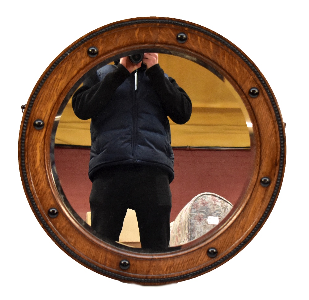 A 1920s/30s oak wall mirror.Additional InformationDiameter 65cm, depth 4cm. Postage would likely