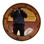A 1920s/30s oak wall mirror.Additional InformationDiameter 65cm, depth 4cm. Postage would likely