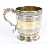 A George III hallmarked silver mug with foliate bands and double scroll handle, with traces of