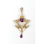 An Edwardian 9ct yellow gold floral motif open work pendant set with two purple coloured stones