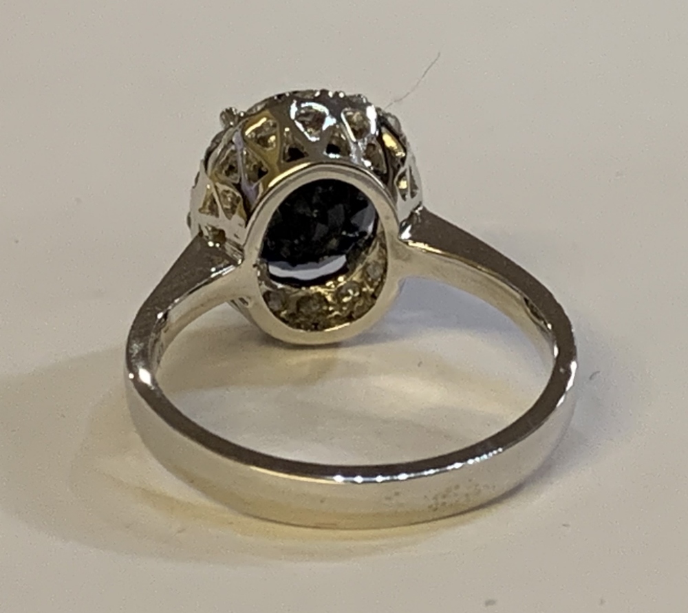A white metal diamond and sapphire cluster ring, the modified brilliant cut sapphire weighing approx - Image 4 of 5