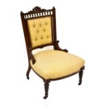 A Victorian nursing chair, with button back panel, raised on tapering column supports terminating on