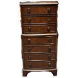 A reproduction mahogany chest of drawers in the form of a miniature tallboy.