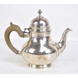 CJ VANDER; an Elizabeth II hallmarked silver teapot with cast finial on spreading circular feet,