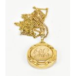 A 9ct yellow gold circular locket, with inscribed monogram, suspended a 9ct yellow gold chain,