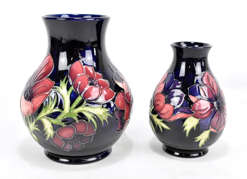 MOORCROFT; two tubeline decorated 'Anemone' pattern baluster vases on navy grounds, marked to