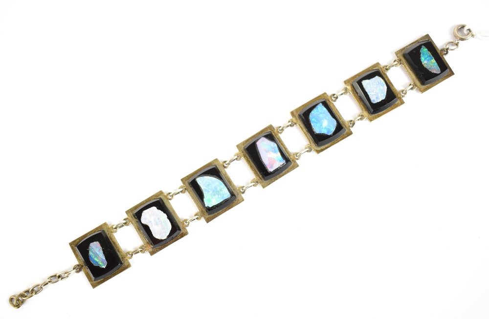 A white metal panel bracelet stamped 'Sterling' to clasp, set with cut sections of opal, length 15.