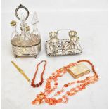 A silver plated condiment stand with pierced detail on four claw feet housing four clear glass