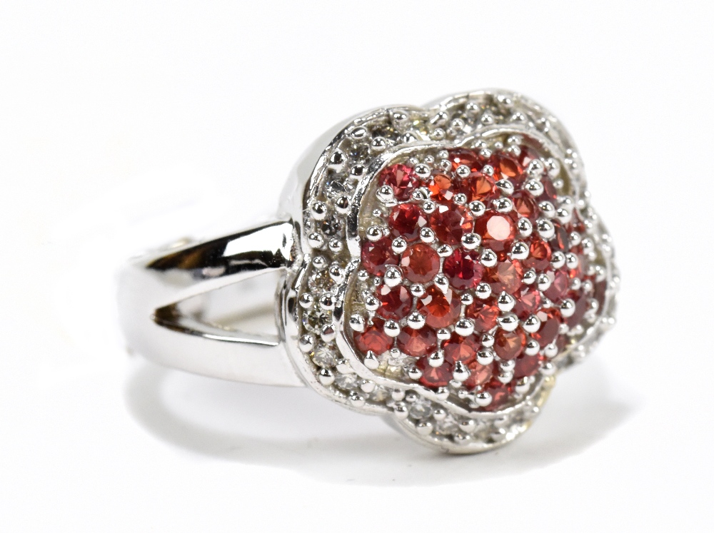 A white metal diamond and red sapphire cluster ring, the round sapphires approx total 1.1ct and