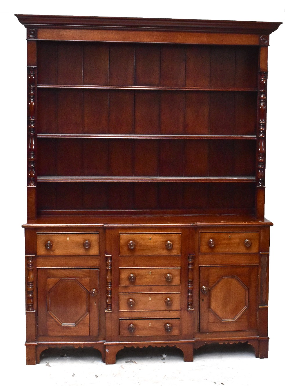 A Victorian mahogany breakfront dresser, with plate rack back above four central drawers flanked