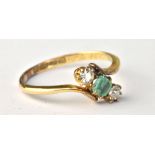 An 18ct yellow gold diamond and emerald three stone ring, the diamond approx 0.10cts, the band